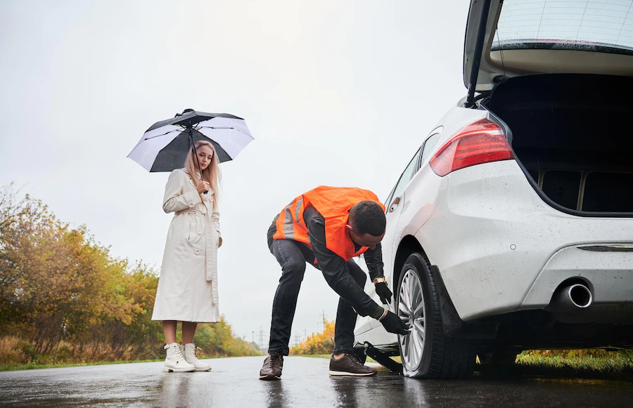 roadside-assistance-worker-repairing-woman-vehicle-street